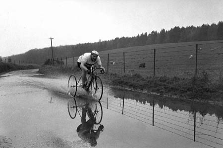 Norman Wiles cycles through flooded road